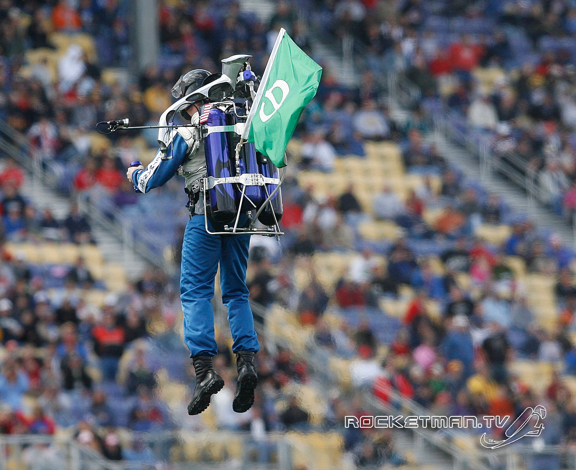 The Rocketman flying with a flag over a packed stadium