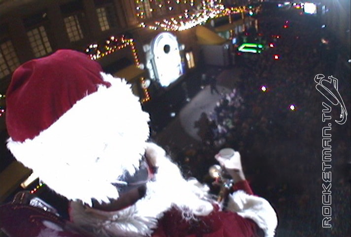 The Rocketman as Santa Claus flying over a city at night