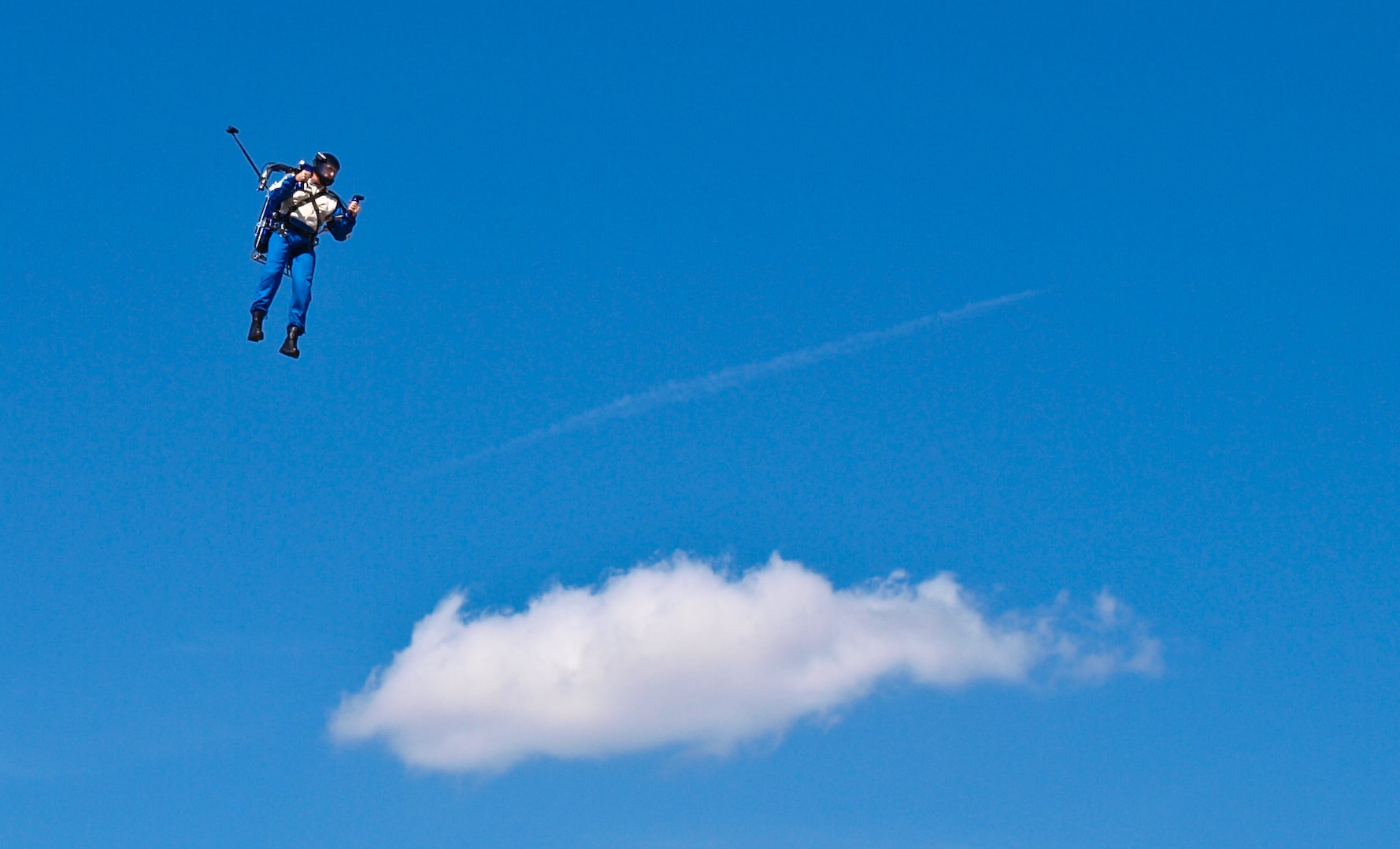 The Rocketman soaring high above the clouds against a blue sky